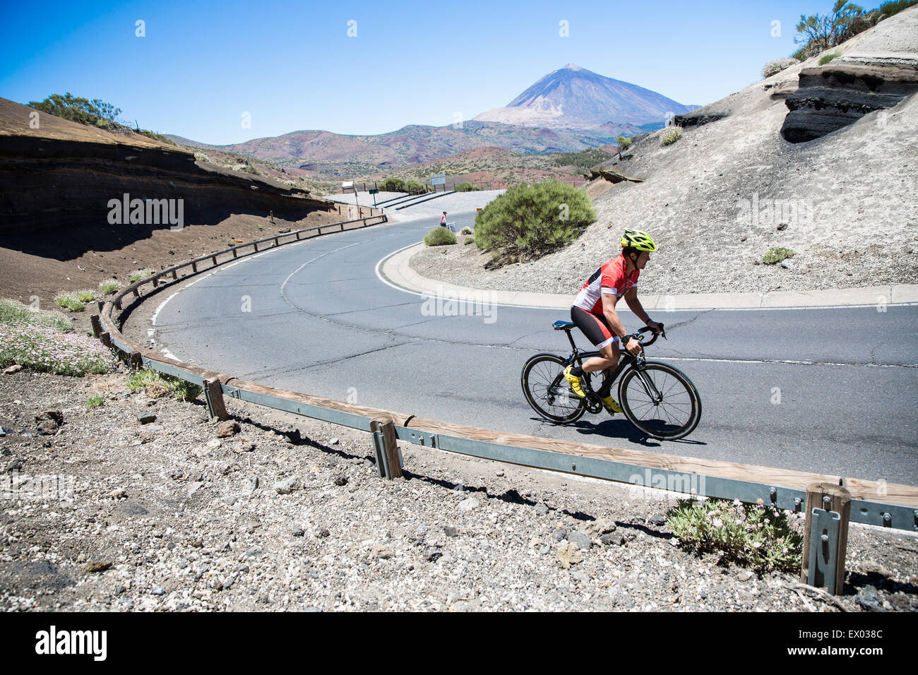 Male cyclist cycling up winding road, Tenerife, Canary Islands, Spain Stock Photo