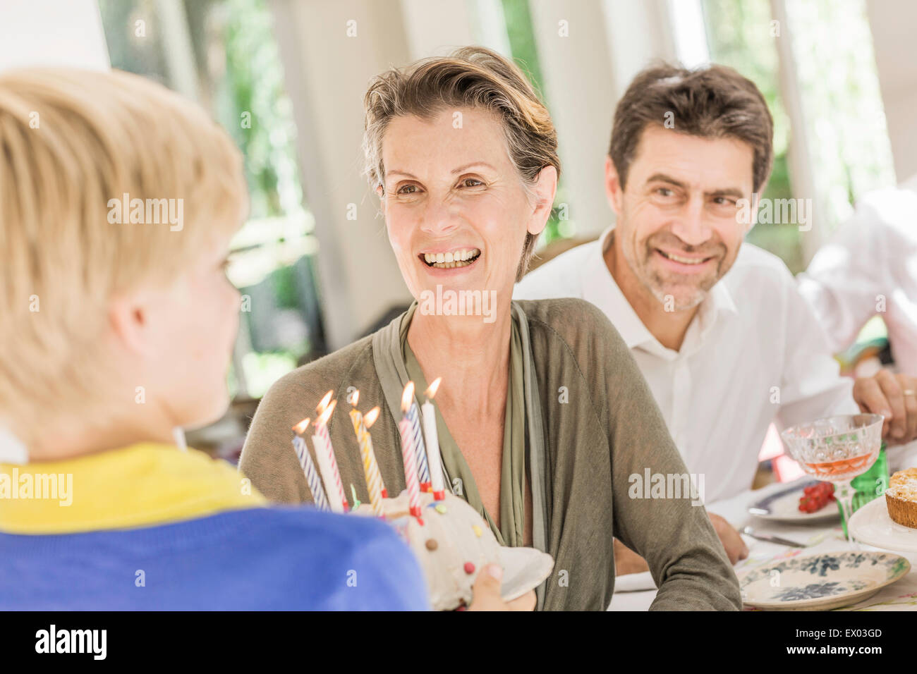 Boy handing birthday cake to grandmother at  party Stock Photo