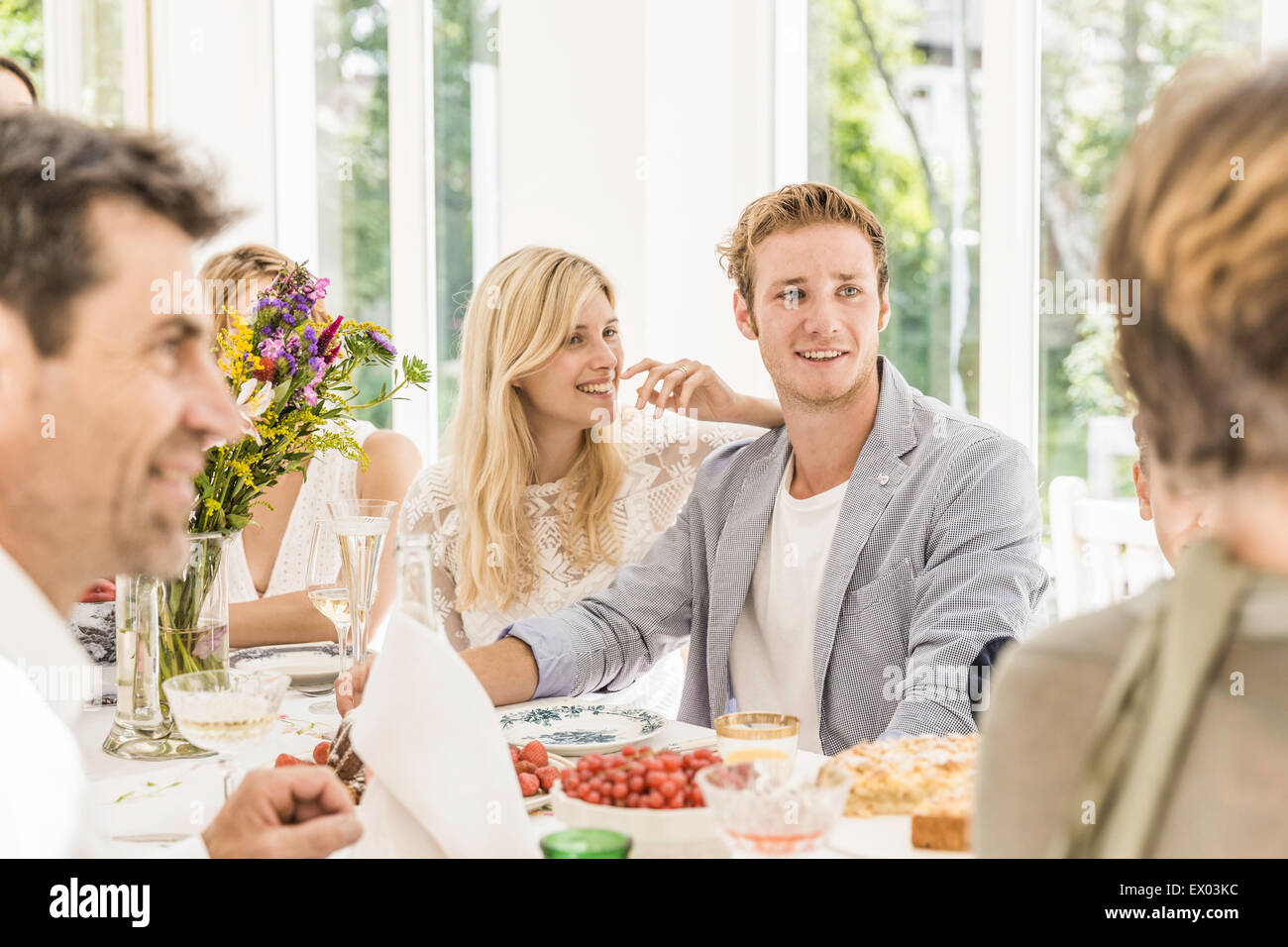 Family adults chatting at birthday party table Stock Photo