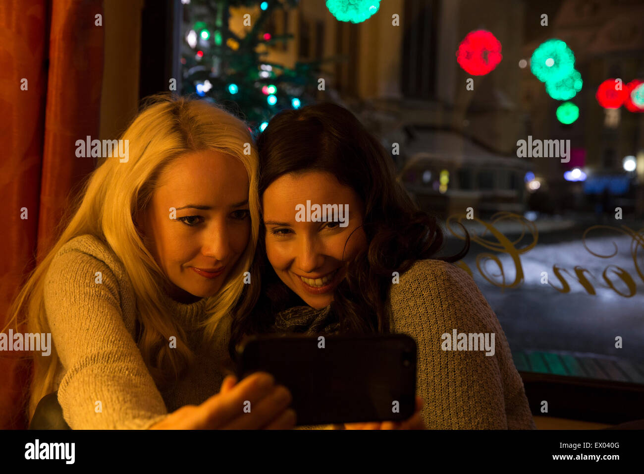 Mid adult women in cafe photographing themselves Stock Photo