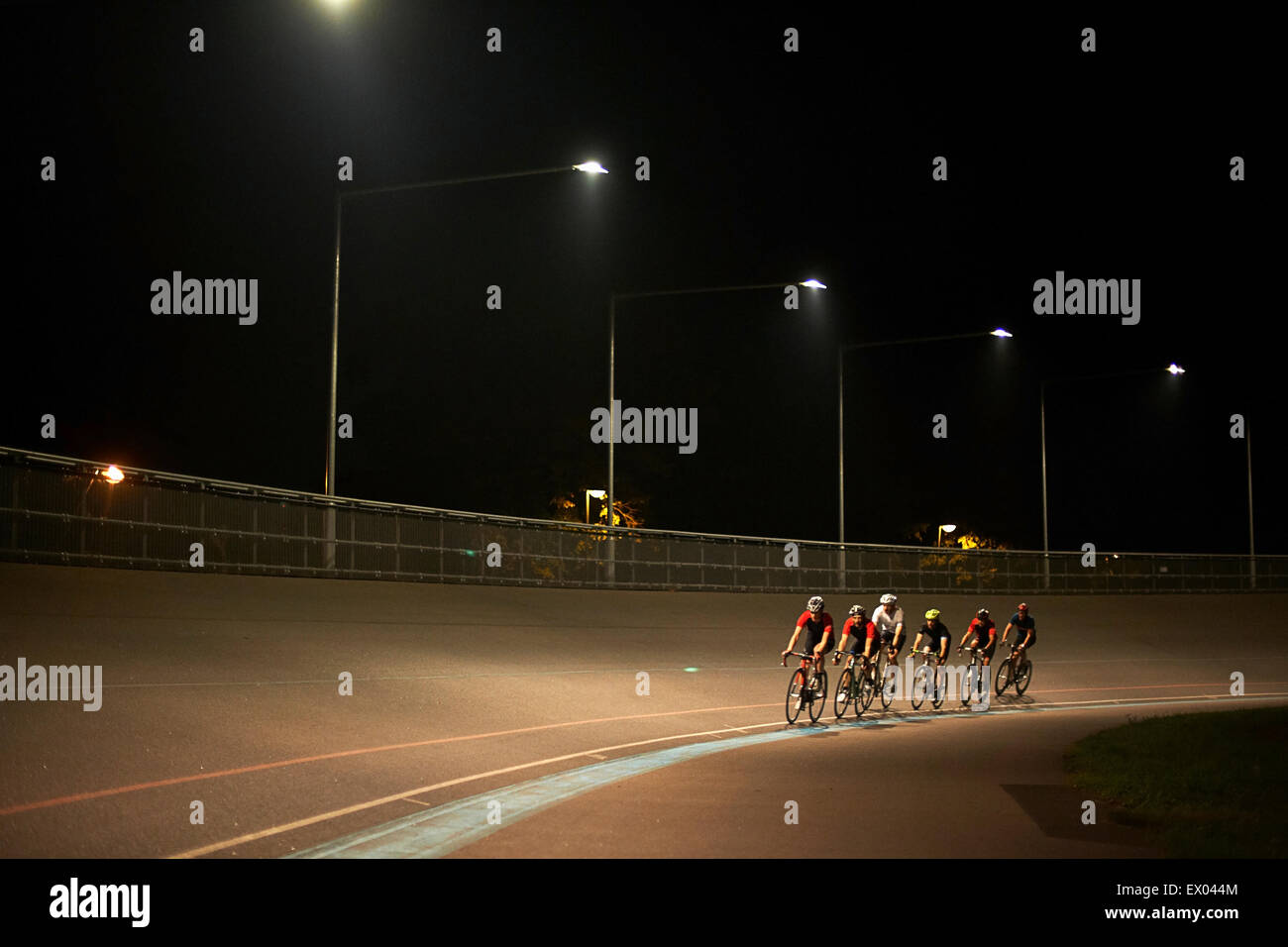 Cyclists cycling on track at velodrome, outdoors Stock Photo