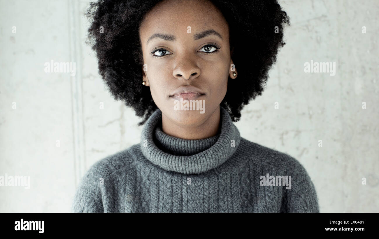 Portrait of confident young woman in front of wall Stock Photo