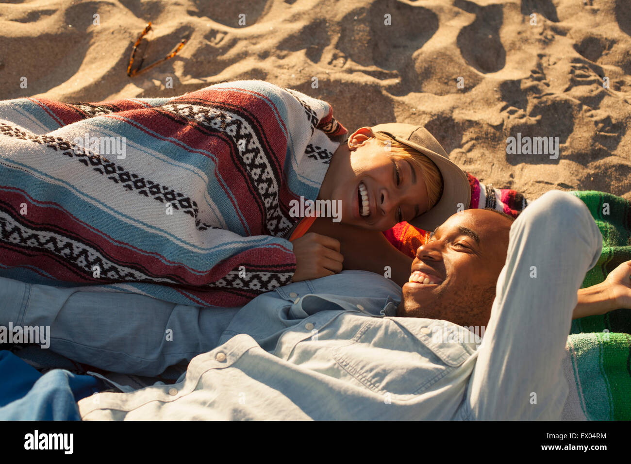 Young couple lying together on beach Stock Photo - Alamy