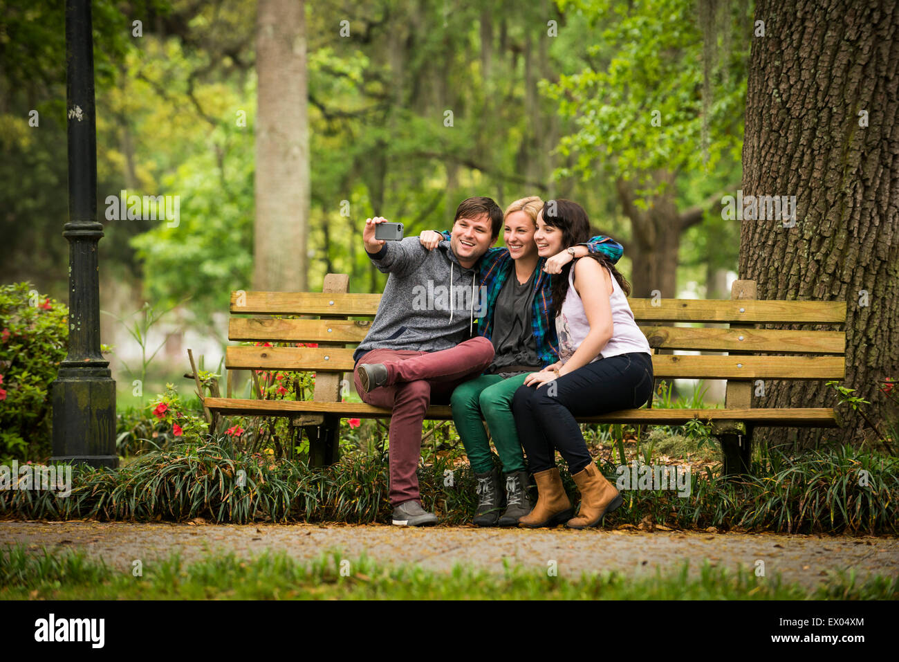 friends-taking-selfie-on-park-bench-savannah-georgia-usa-EX04XM.jpg