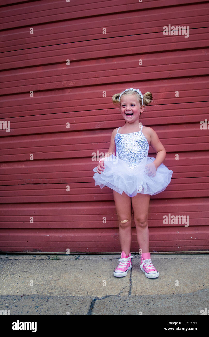 Young girl wearing tutu and pink baseball boots, plaster on knee Stock Photo