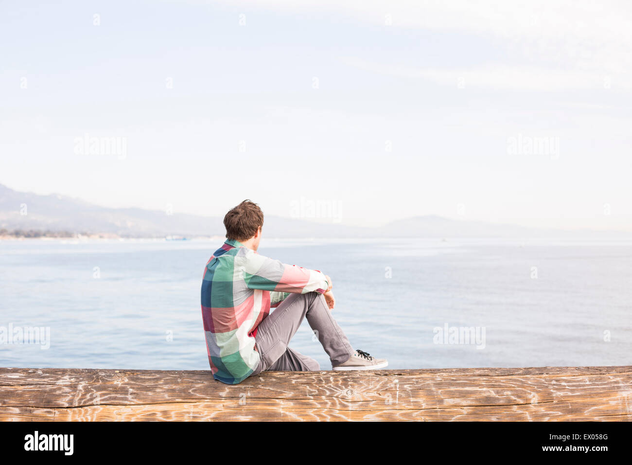 Young man looking at view across the water Stock Photo