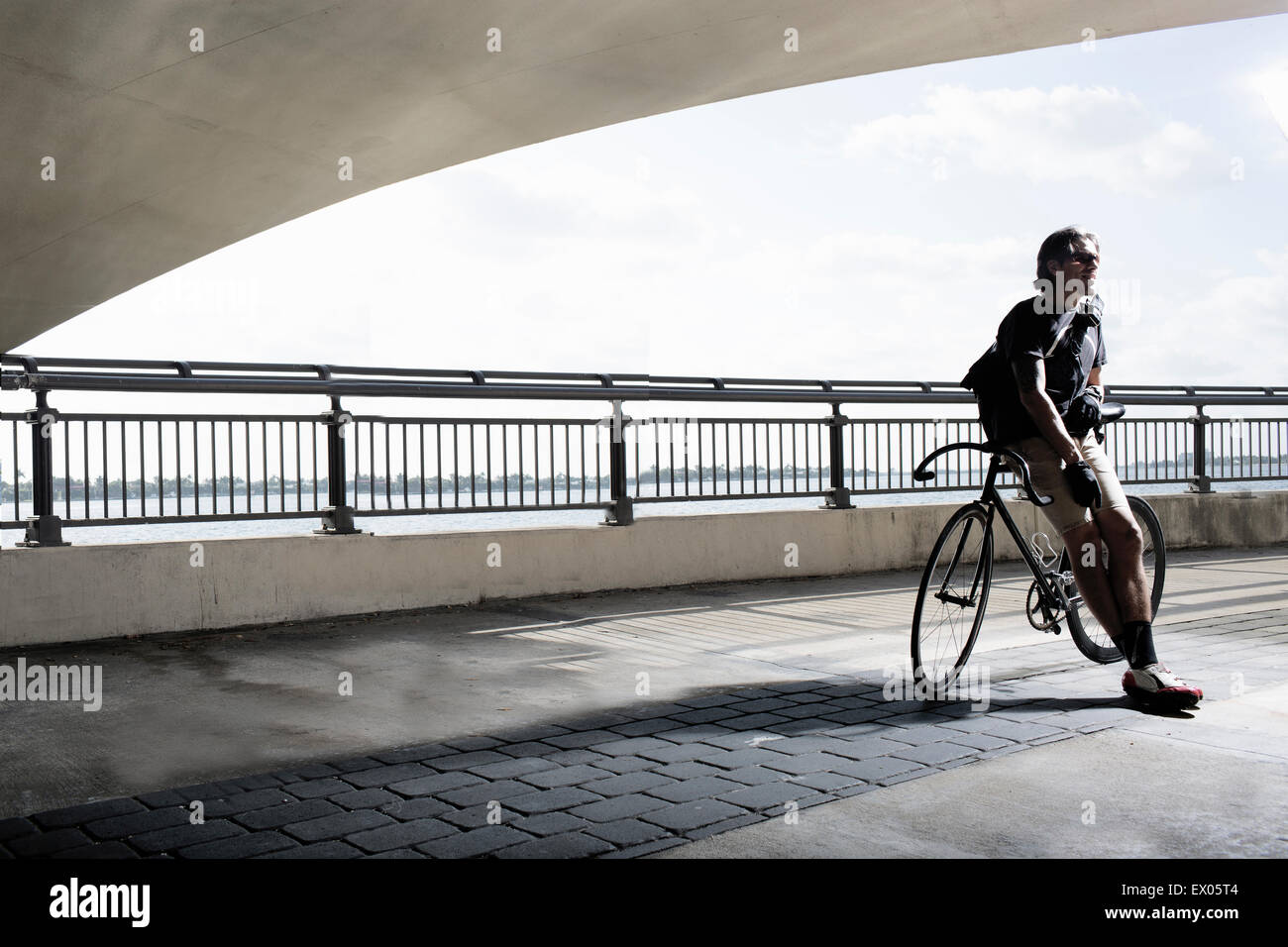 Bike messenger leaning on bike Stock Photo