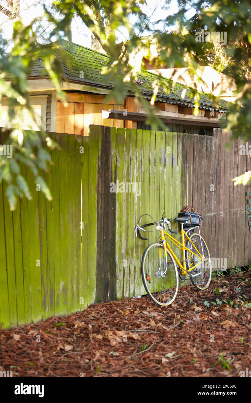 Bicycle leaning against fence Stock Photo