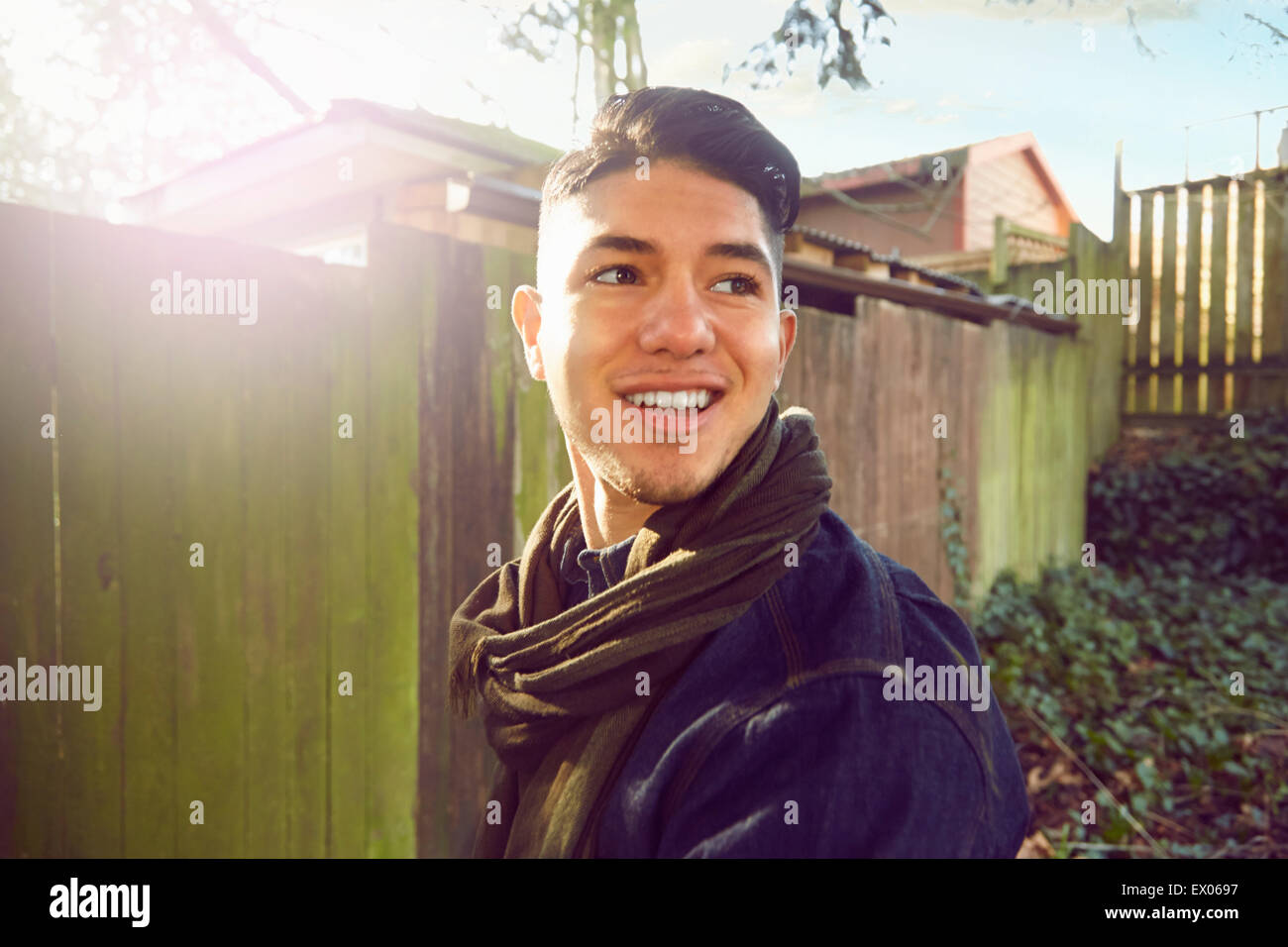 Young man with quiff looking away, smiling Stock Photo