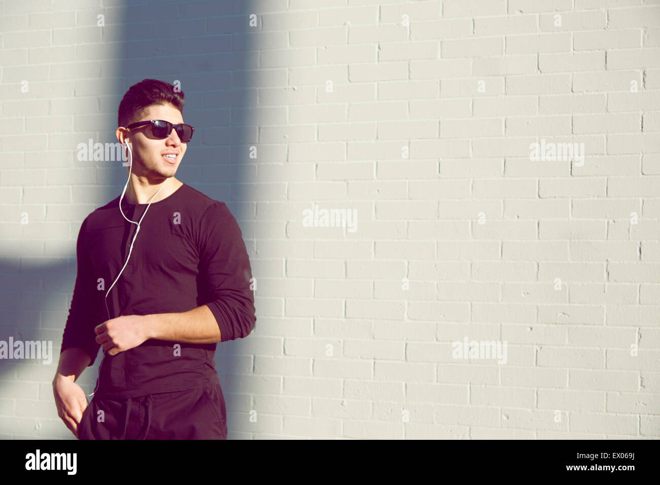 Young man wearing sunglasses by white wall Stock Photo