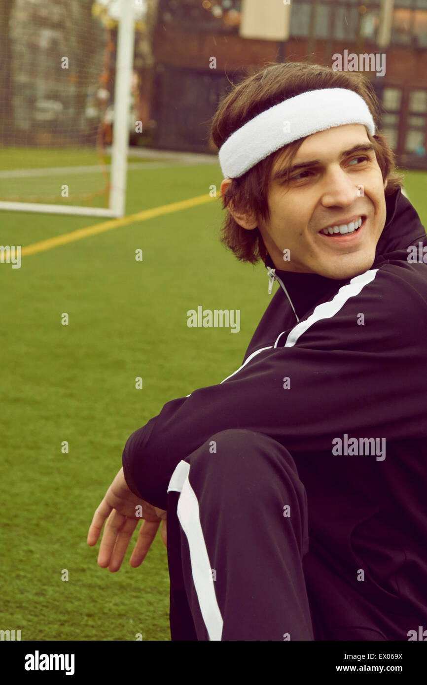 Mid adult man warming up on soccer pitch Stock Photo