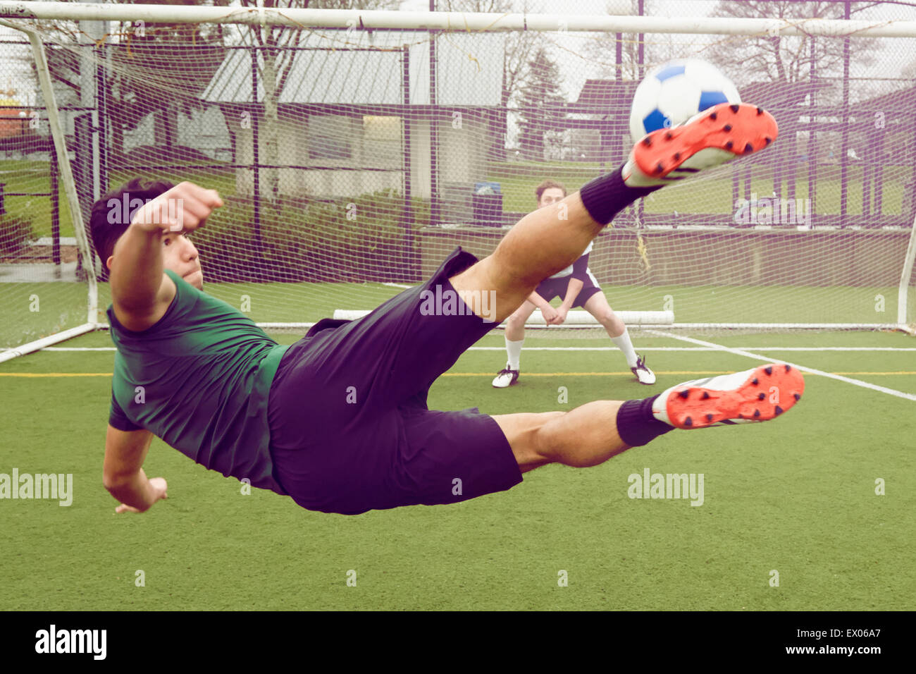 Young male soccer player kicking ball toward goal Stock Photo - Alamy