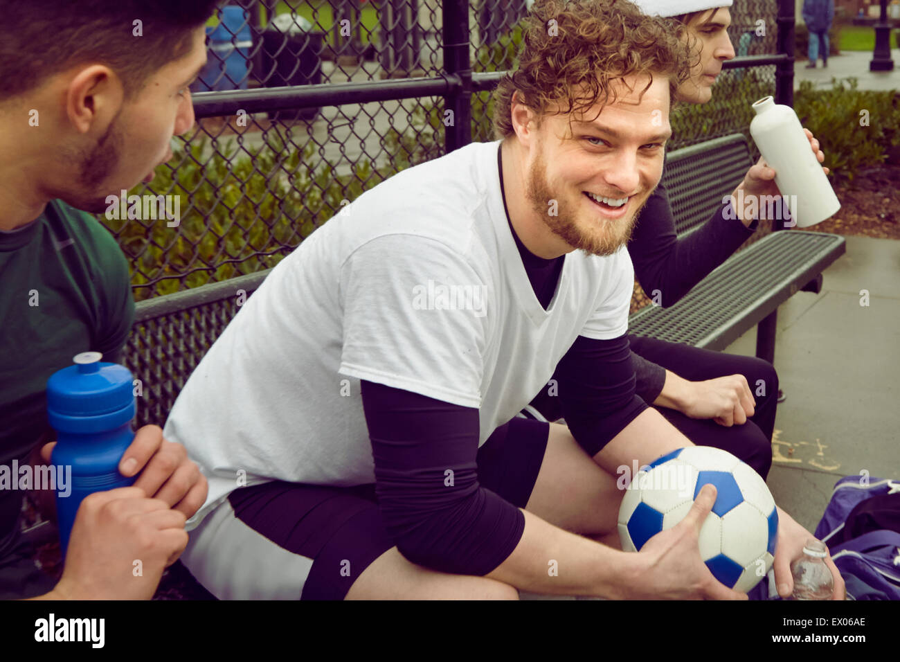 Three male soccer players taking a break Stock Photo