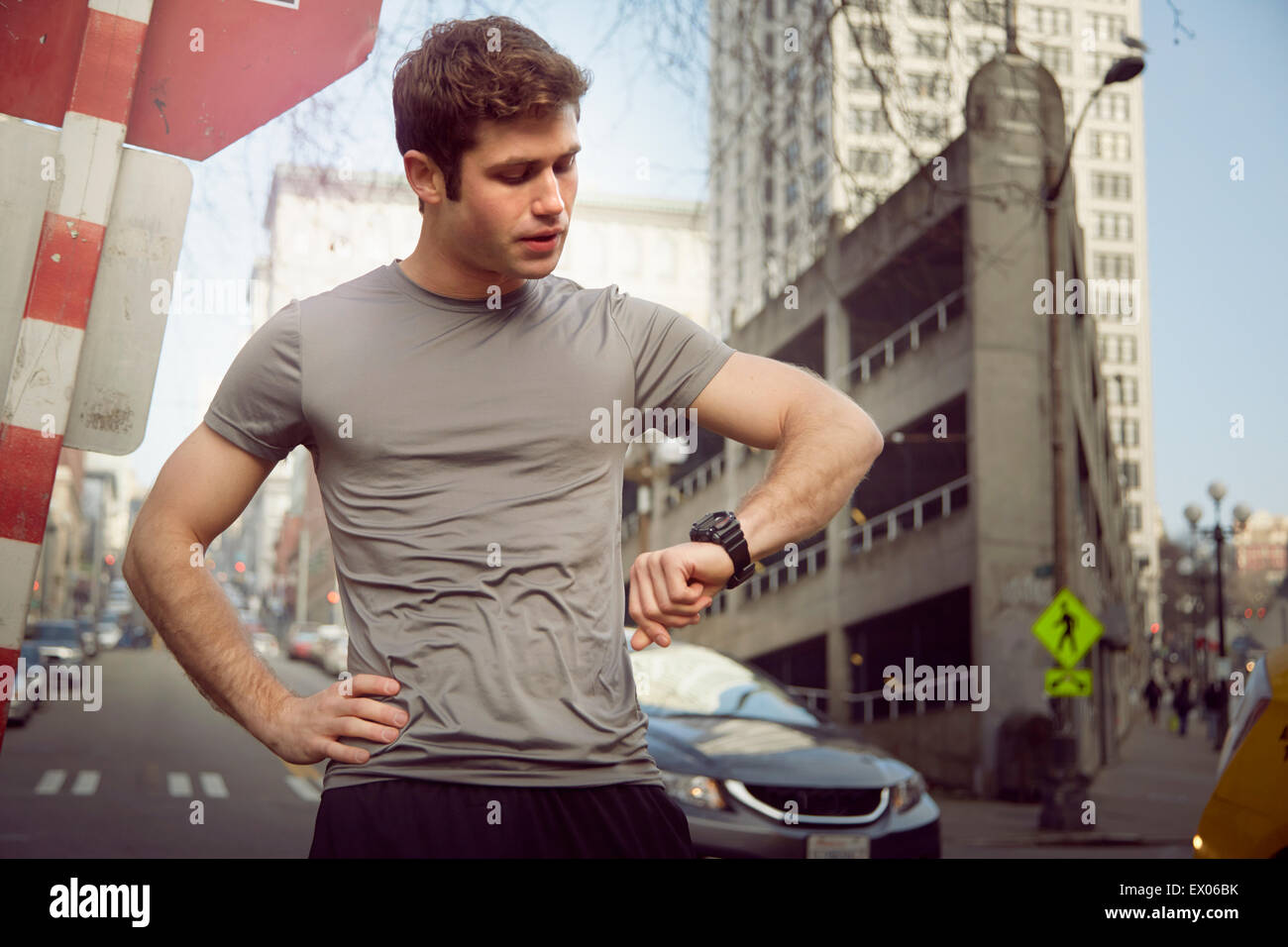 Young male runner checking wristwatch, Pioneer Square, Seattle, USA Stock Photo