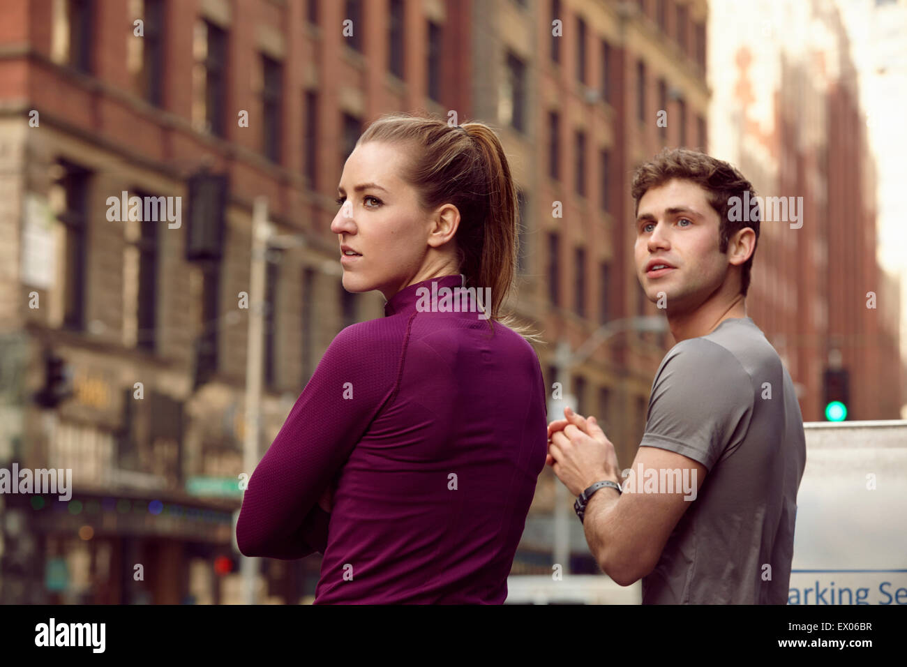 Male and female runners waiting to cross street, Pioneer Square, Seattle, USA Stock Photo