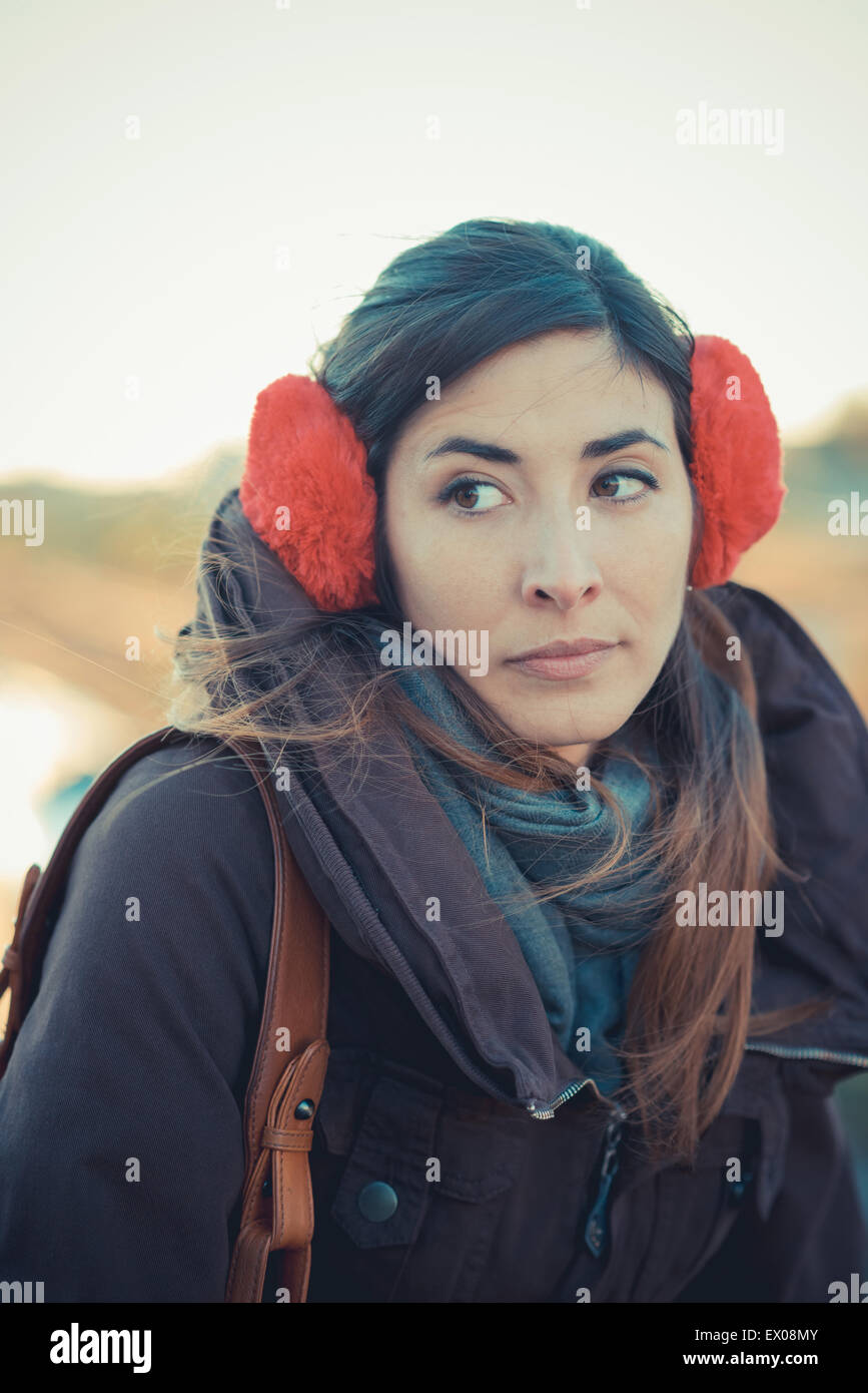 Mid adult woman wearing red ear muffs in park Stock Photo