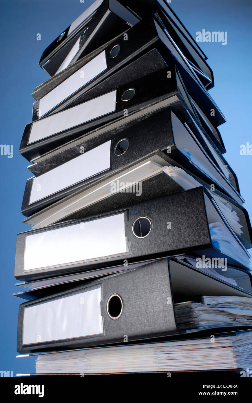 A stack of file folders on a blue background. Stock Photo