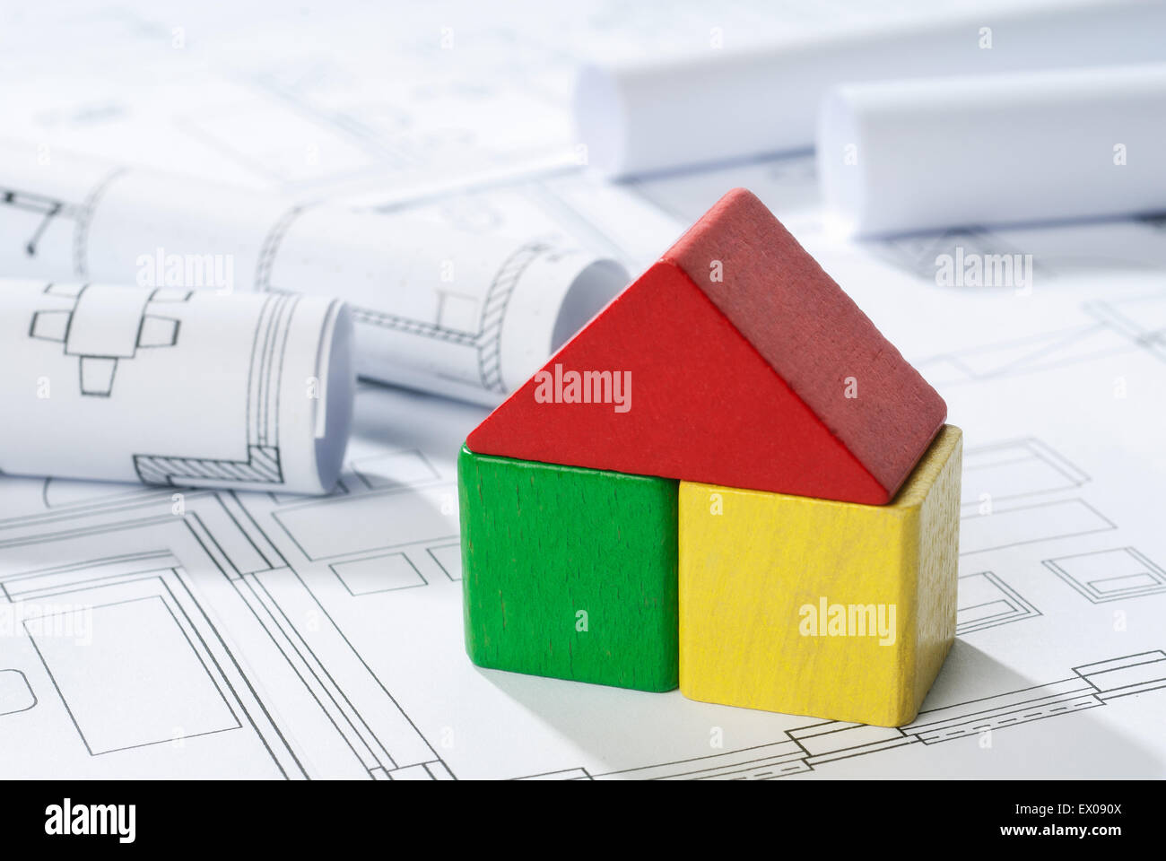 House of differently colored building blocks on blueprint. Stock Photo