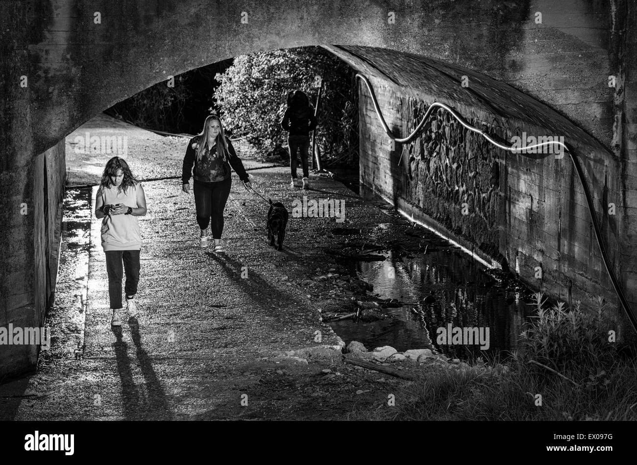 People walking though a tunnel at night. Stock Photo