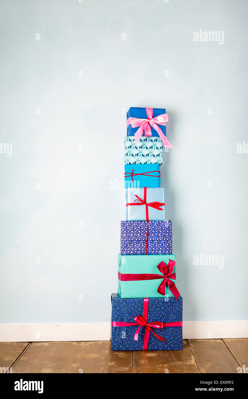 Stack of six wrapped christmas gifts on wooden floor Stock Photo