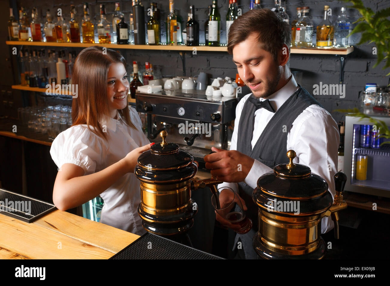 Bartender and a waitress in the bar Stock Photo - Alamy