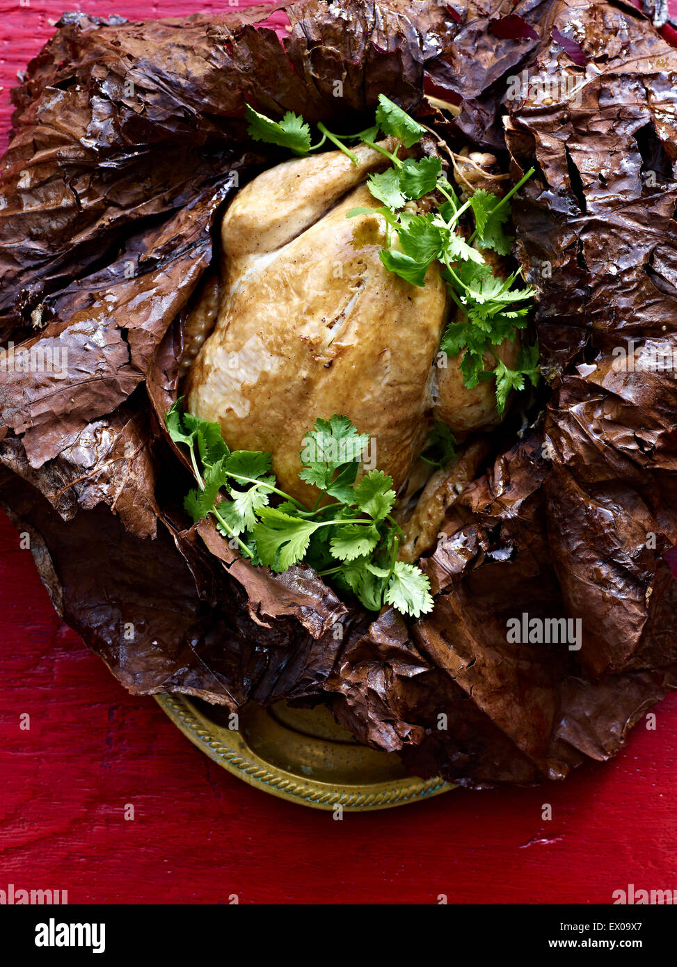 Still life of Beggars Chicken wrapped in lotus leaf with coriander ...