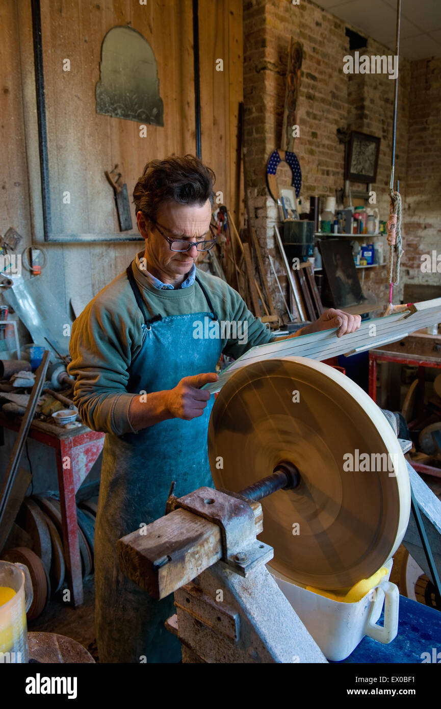 Glass engraver examining glass material in workshop Stock Photo