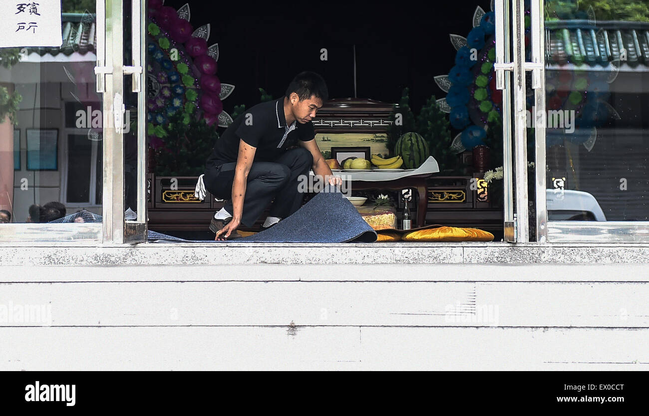 Changchun, China's Jilin Province. 3rd July, 2015. A staff member lays a blanket at a funeral hall for victims in Ji'an, northeast China's Jilin Province, July 3, 2015. A deadly bus accident happened in Ji'an on July 1, killing 10 South Korean tourists and a Chinese driver. Some family members of the victims began arriving in Ji'an. Credit:  Wang Haofei/Xinhua/Alamy Live News Stock Photo