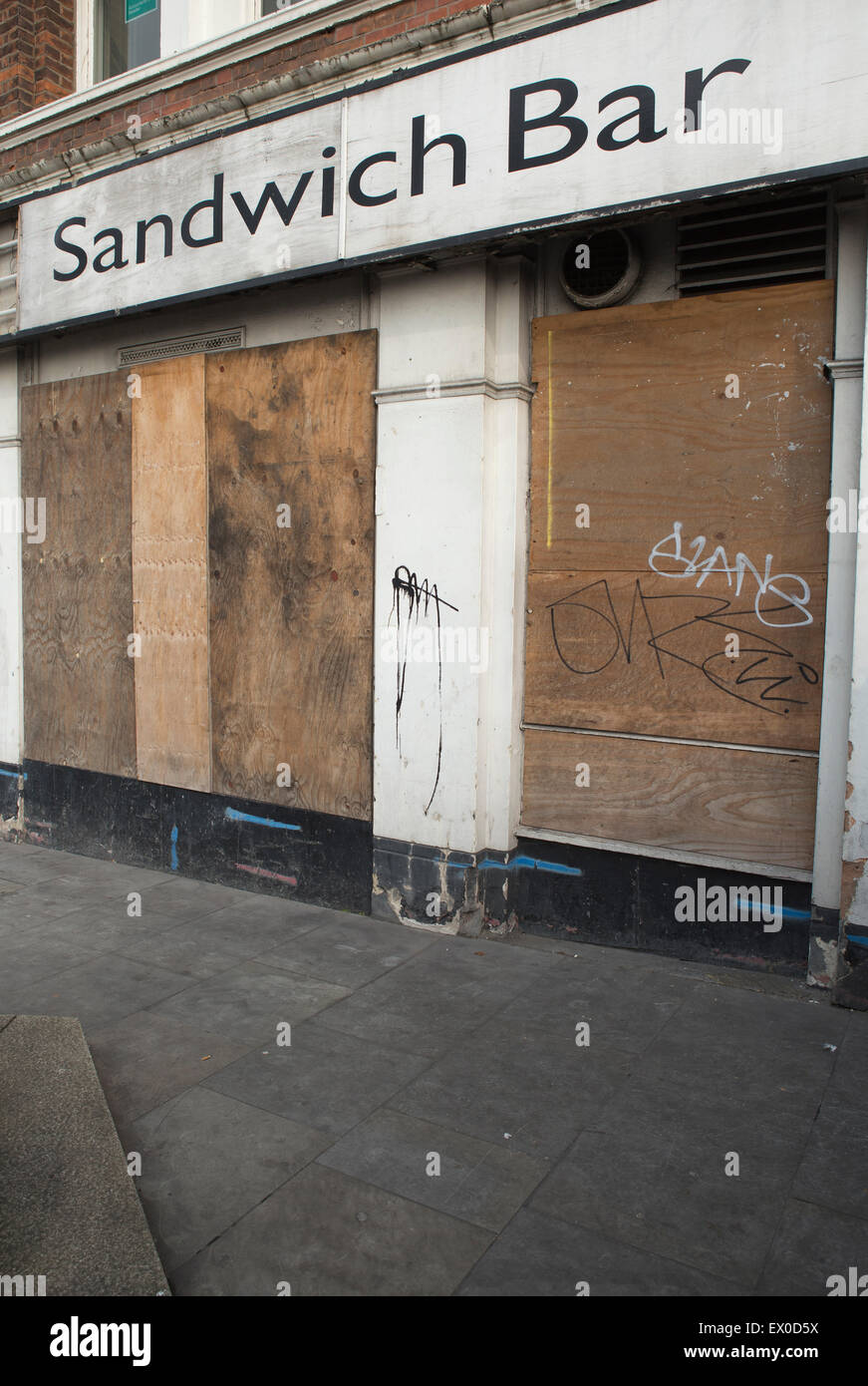 A derelict sandwich bar boarded up after being closed down. Stock Photo