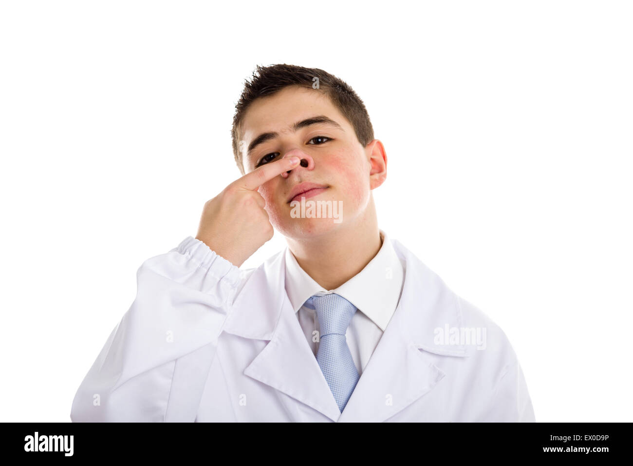 child dressed as a doctor in light blue tie and white coat helps to feel medicine more friendly: he is touching and pushing up his nose. His acne skin has not ben retouched Stock Photo