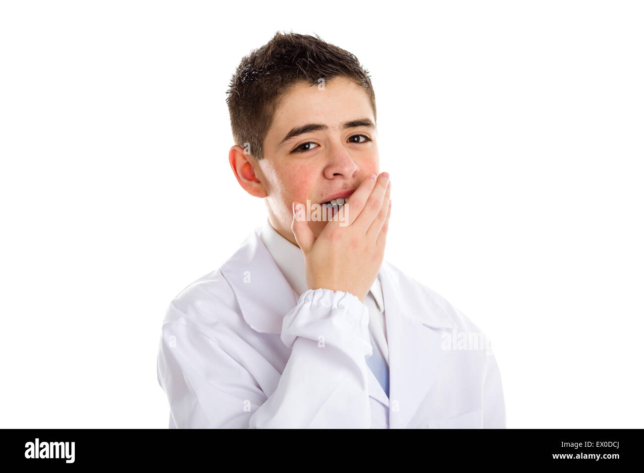 child dressed as a doctor in light blue tie and white coat helps to feel medicine more friendly: he is yawning while covering mouth with hand. His acne skin has not ben retouched Stock Photo