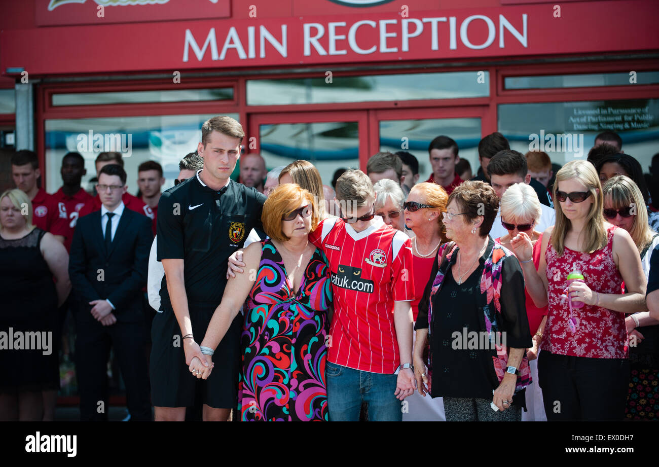 Walsall, West Midlands, UK. 03rd July, 2015. Grieving mother, daughter and sister Suzanne Evans stands with her son Owen Richards and Maureen Evans among hundreds of people who joined the nation as it fell silent at noon, a week after 38 people were gunned down by 23-year-old student Seifeddine Rezgui at the beach resort of Sousse. The victims include three members of the same family, Walsall FC supporters, Joel Richards, Adrian Evans and Patrick Evans. Credit:  Jane Williams/Alamy Live News Stock Photo