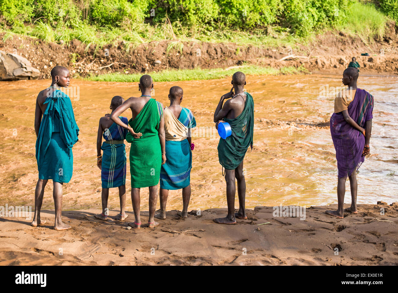 Young adults of the African tribe Suri standing on the banks of a river Stock Photo