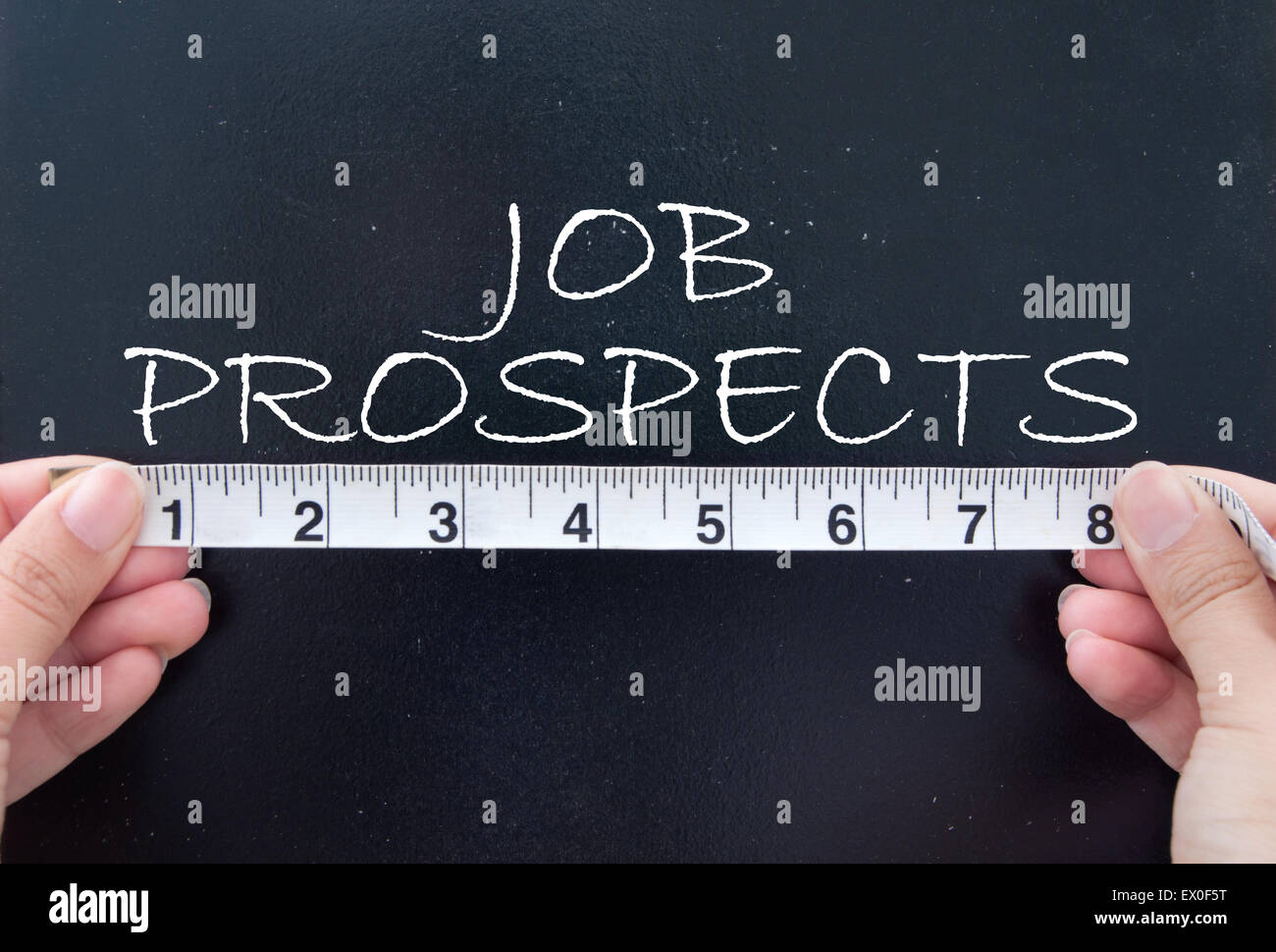 Tape measuring the job prospects handwritten on a chalkboard Stock Photo