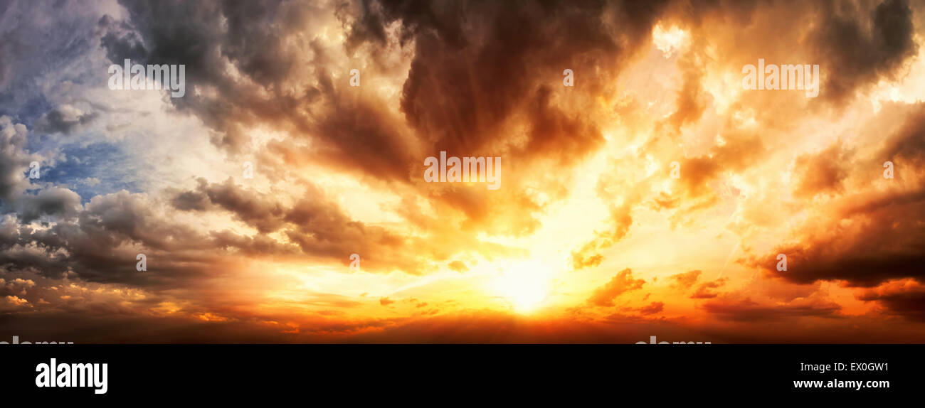 Dramatic sunset sky panorama with the clouds glowing in vivid warm colors Stock Photo