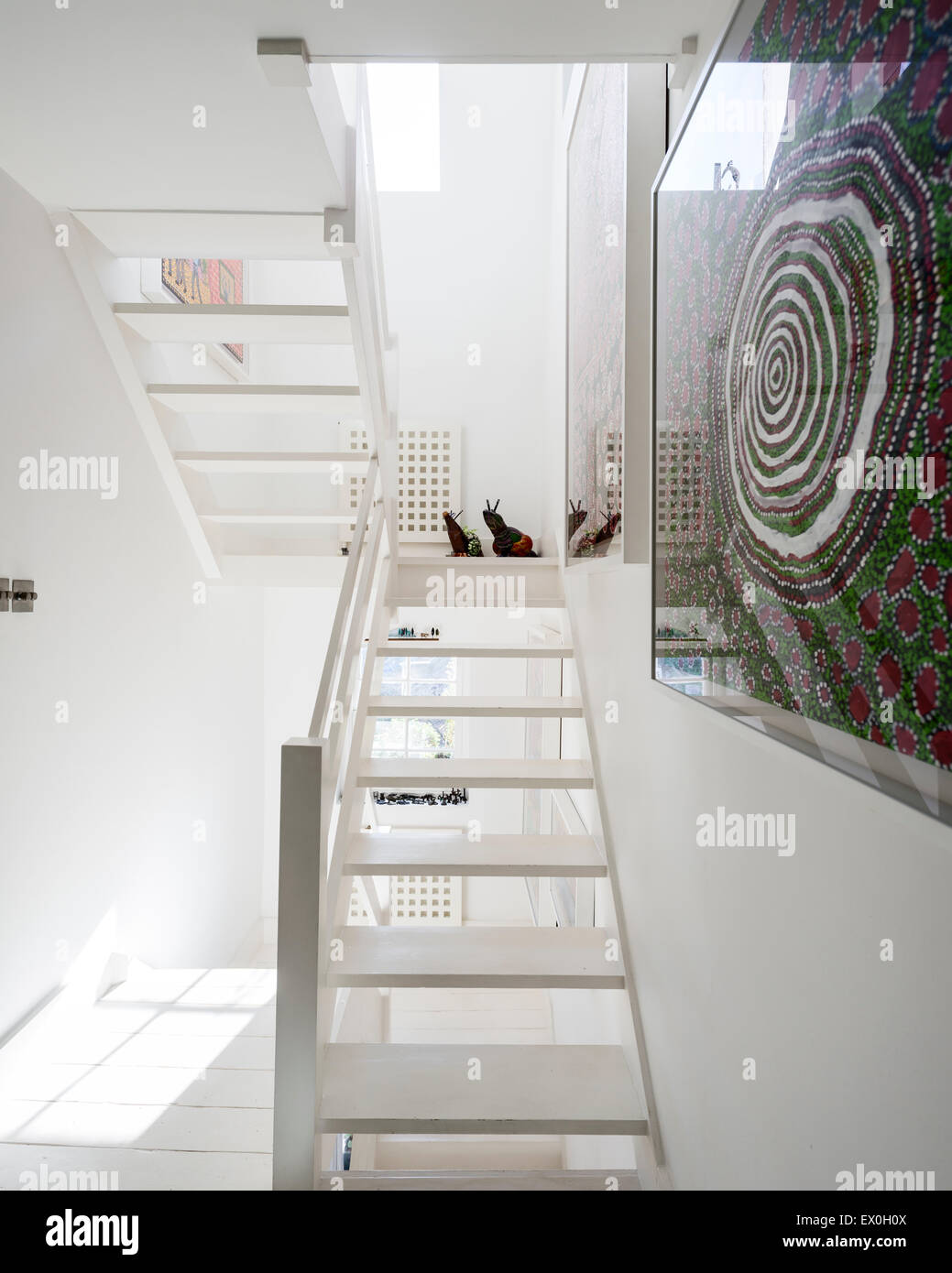 White wooden staircase with art by the Spinifex Hill Artists on the wall Stock Photo