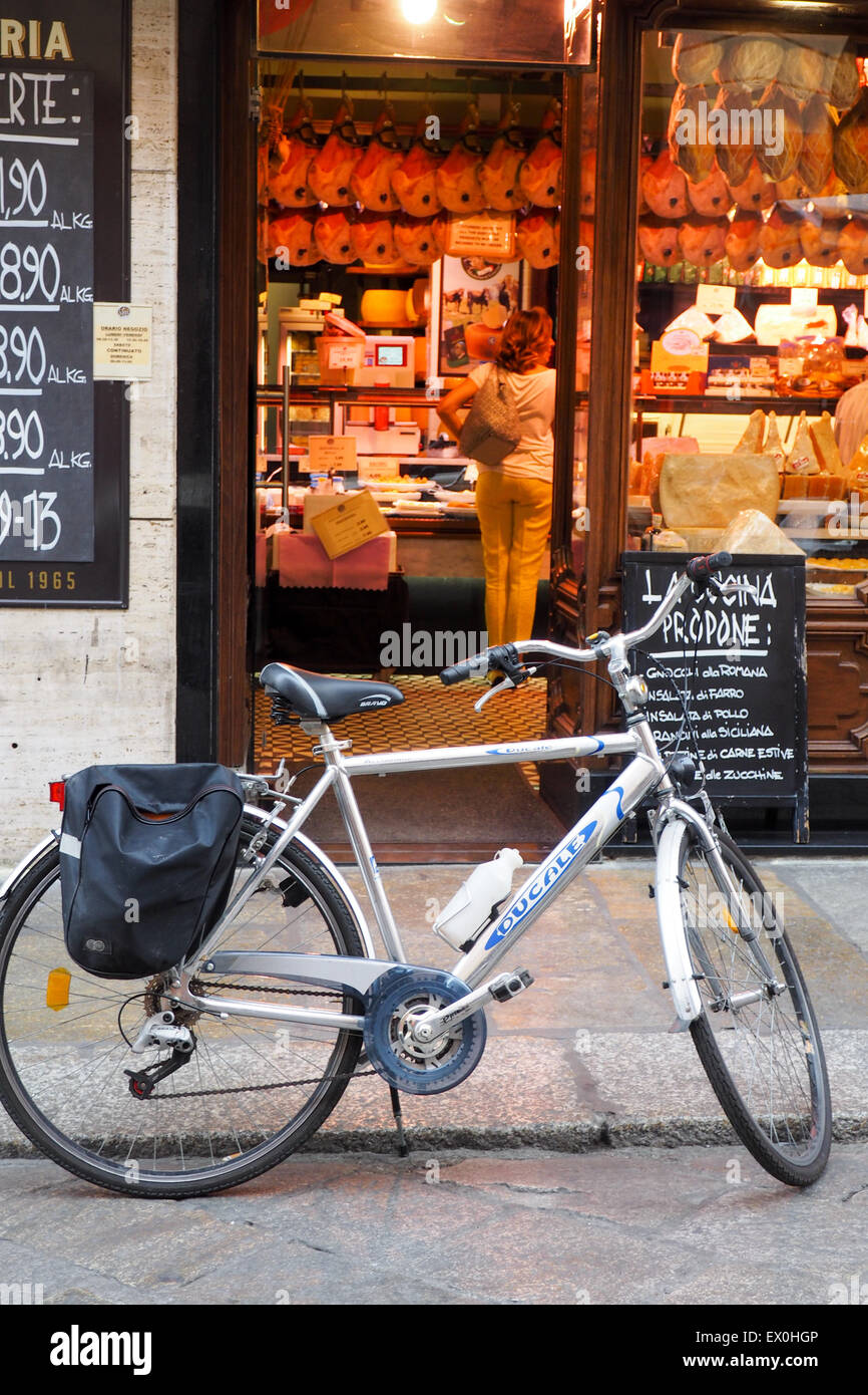 A bicycle parked outside a prosciutteria store, where Parma ham can be bought. Stock Photo