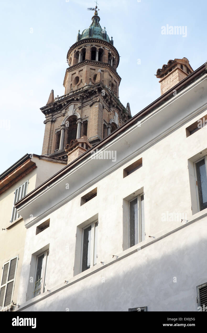 A white building with the the bell tower of San Giovanni Evangelista church in the background,  Parma, Italy. Stock Photo