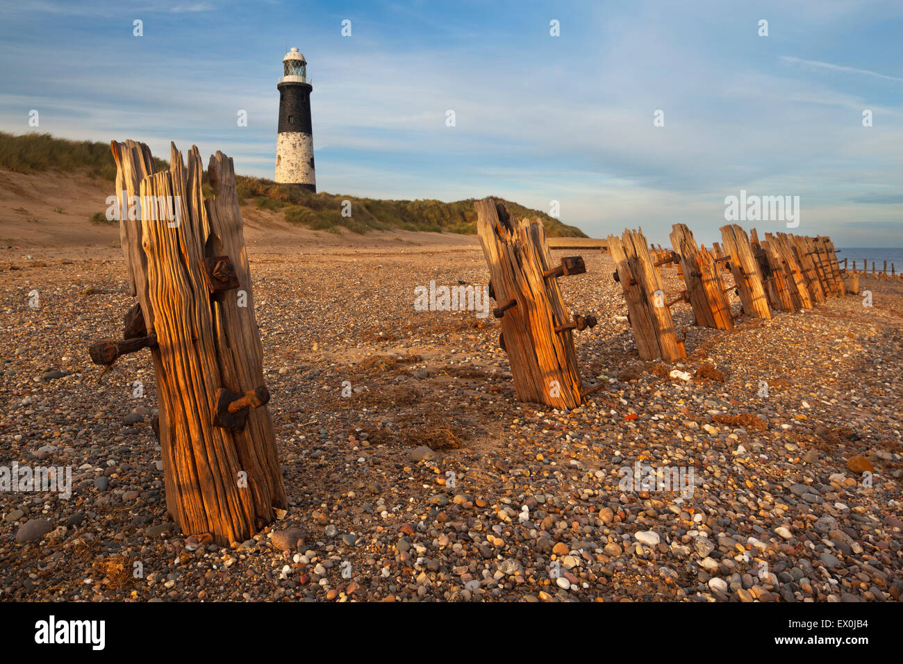 Sea defences along the beach and a view towards the Spurn Lighthouse at Spurn Point, Humberside, East Yorkshire, UK Stock Photo