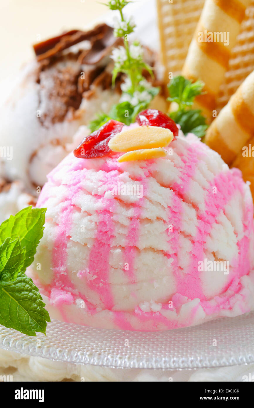 Scoops of ice cream garnished with wafers and herbs Stock Photo