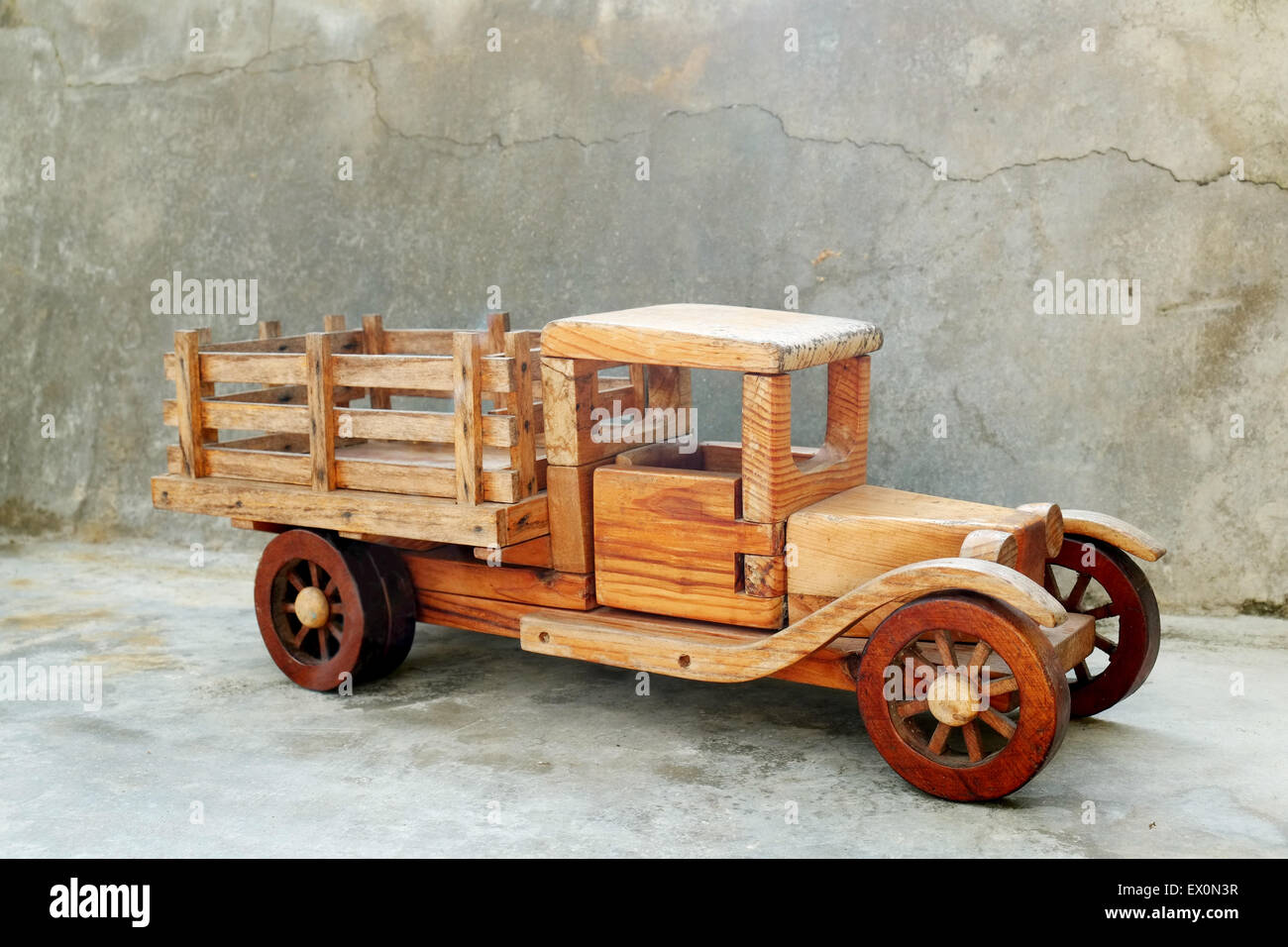 Old wood toy truck with a gray concrete grungy  background Stock Photo