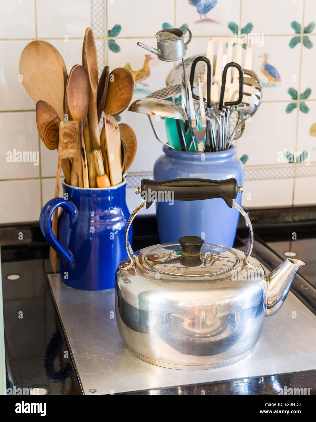 Aga kettle and wooden spoons in blue jug Stock Photo