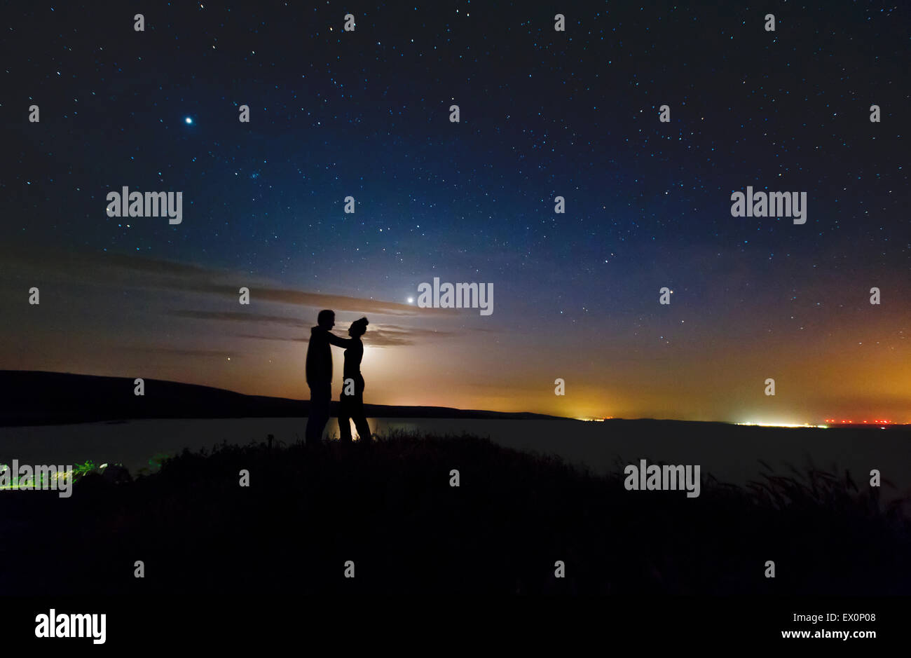 Romantic couple on sunset over the mountain Stock Photo