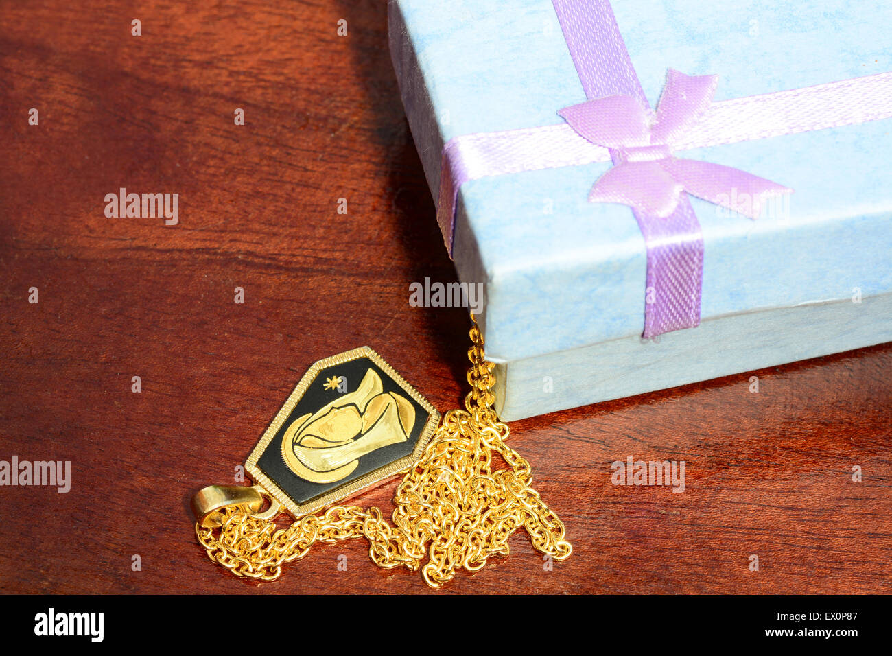 Girls chain and pendant coming out of a small gift box Stock Photo