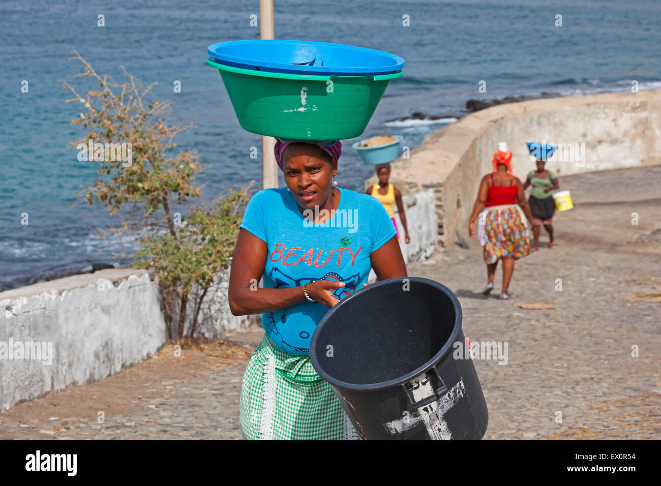 Creole women carrying tubs with fish and other goods out of the harbour of Tarrafal on the island Santiago, Cape Verde, Africa Stock Photo