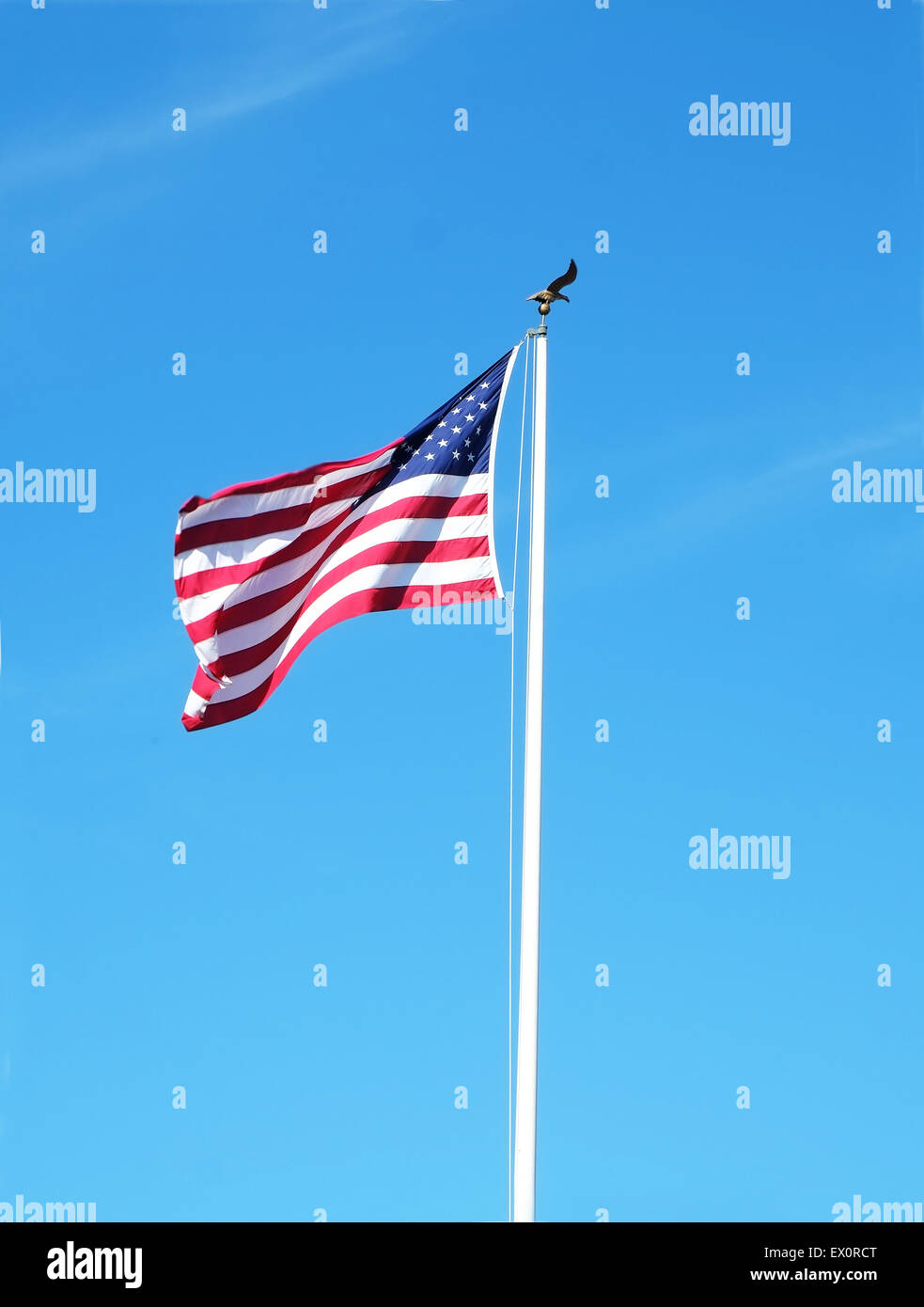United States flag on a pole with a bright blue sky Stock Photo