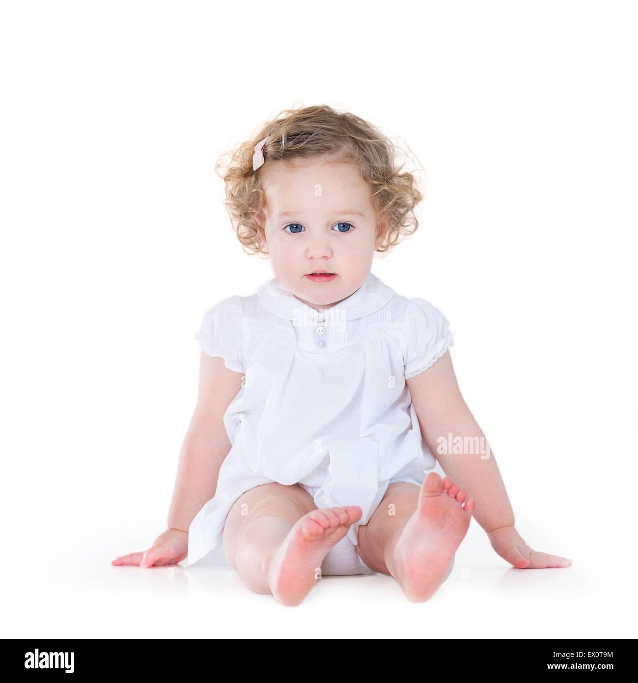 Beautiful Baby Girl With Curly Hair Wearing A Nice White Dress On