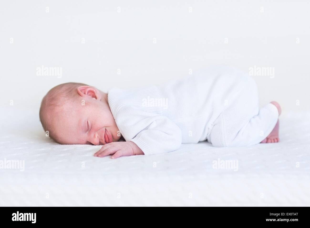 Little newborn baby sleeping on a white knitted blanket Stock Photo Alamy