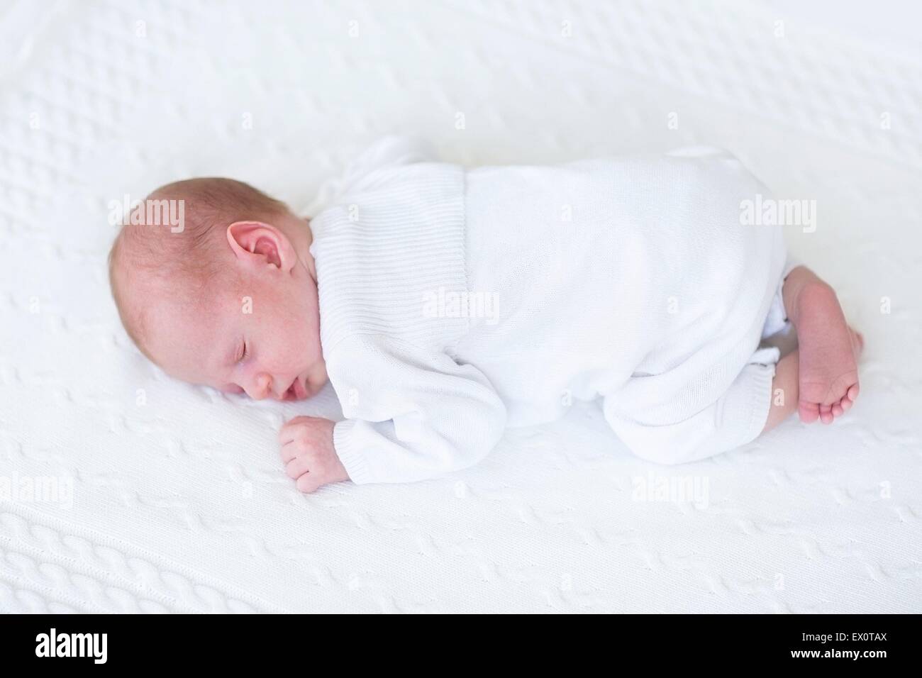 Little newborn baby sleeping on a white knitted blanket Stock Photo Alamy