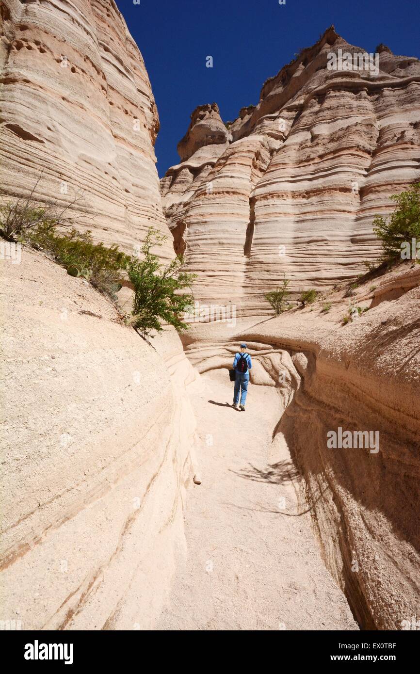 We are but a small part  of  this world - woman hiking among massive cliffs in slot canyon of New Mexico Stock Photo